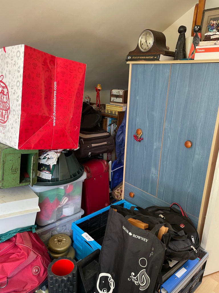Attic space before clearing and the bookshelves and wardrobe are inaccessible